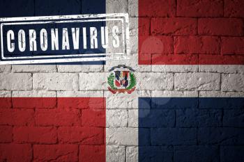 Flag of the Dominican Republic with original proportions. stamped of Coronavirus. brick wall texture. Corona virus concept. On the verge of a COVID-19 or 2019-nCoV Pandemic.