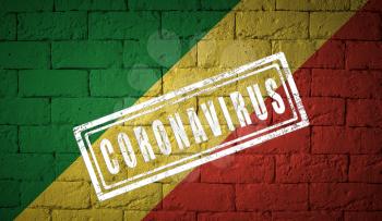 Flag of the Republic o the Congo on brick wall texture. stamped of Coronavirus. Corona virus concept. On the verge of a COVID-19 or 2019-nCoV Pandemic. Novel Chinese Coronavirus outbreak