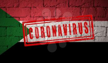 Flag of the Sudan on brick wall texture. stamped of Coronavirus. Corona virus concept. On the verge of a COVID-19 or 2019-nCoV Pandemic. Novel Chinese Coronavirus outbreak