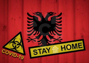 Flag of the Albania in original proportions. Quarantine and isolation - Stay at home. flag with biohazard symbol and inscription COVID-19.