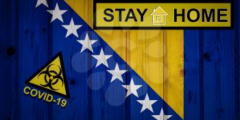 Flag of the Bosnia and Herzegovina in original proportions. Quarantine and isolation - Stay at home. flag with biohazard symbol and inscription COVID-19.