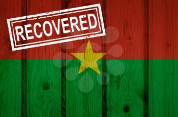 flag of Burkina Faso that survived or recovered from the infections of corona virus epidemic or coronavirus. Grunge flag with stamp Recovered
