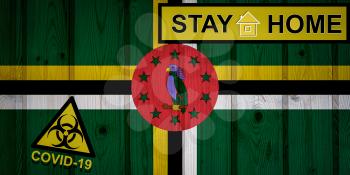 Flag of the Dominica in original proportions. Quarantine and isolation - Stay at home. flag with biohazard symbol and inscription COVID-19.