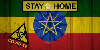 Flag of the Ethiopia in original proportions. Quarantine and isolation - Stay at home. flag with biohazard symbol and inscription COVID-19.