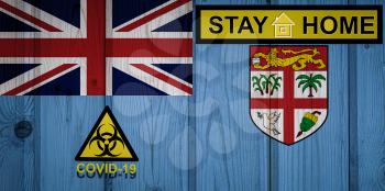 Flag of the Fiji in original proportions. Quarantine and isolation - Stay at home. flag with biohazard symbol and inscription COVID-19.