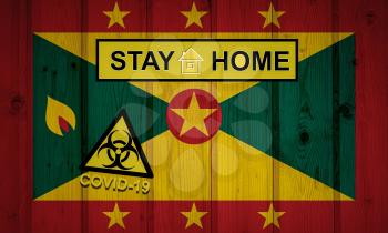 Flag of the Grenada in original proportions. Quarantine and isolation - Stay at home. flag with biohazard symbol and inscription COVID-19.