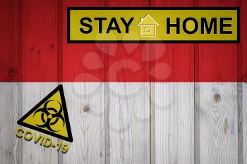 Flag of the Indonesia in original proportions. Quarantine and isolation - Stay at home. flag with biohazard symbol and inscription COVID-19.