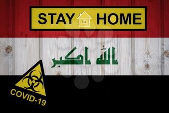 Flag of the Iraq in original proportions. Quarantine and isolation - Stay at home. flag with biohazard symbol and inscription COVID-19.