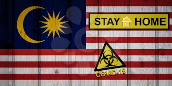 Flag of the Malaysia in original proportions. Quarantine and isolation - Stay at home. flag with biohazard symbol and inscription COVID-19.