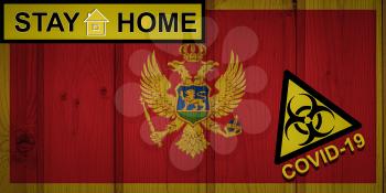 Flag of the Montenegro in original proportions. Quarantine and isolation - Stay at home. flag with biohazard symbol and inscription COVID-19.