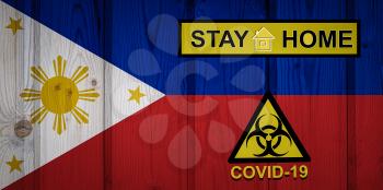 Flag of the Philippines in original proportions. Quarantine and isolation - Stay at home. flag with biohazard symbol and inscription COVID-19.