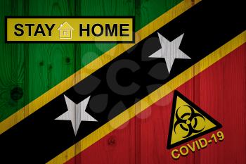 Flag of the Saint Kitts and Nevis in original proportions. Quarantine and isolation - Stay at home. flag with biohazard symbol and inscription COVID-19.
