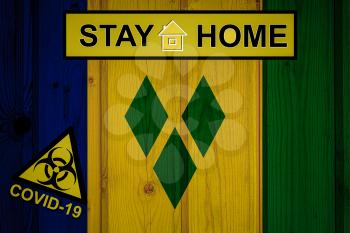Flag of the Saint Vincent and the Grenadines in original proportions. Quarantine and isolation - Stay at home. flag with biohazard symbol and inscription COVID-19.