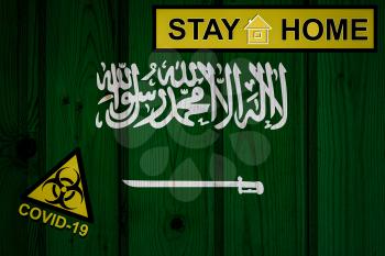 Flag of the Saudi Arabia in original proportions. Quarantine and isolation - Stay at home. flag with biohazard symbol and inscription COVID-19.