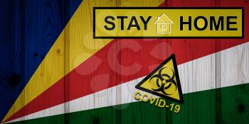 Flag of the Seychelles in original proportions. Quarantine and isolation - Stay at home. flag with biohazard symbol and inscription COVID-19.