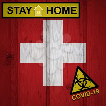 Flag of the Switzerland in original proportions. Quarantine and isolation - Stay at home. flag with biohazard symbol and inscription COVID-19.