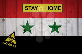 Flag of the Syria in original proportions. Quarantine and isolation - Stay at home. flag with biohazard symbol and inscription COVID-19.