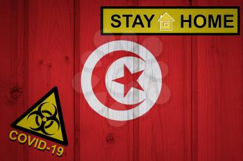 Flag of the Tunisia in original proportions. Quarantine and isolation - Stay at home. flag with biohazard symbol and inscription COVID-19.