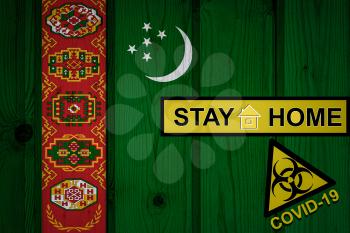 Flag of the Turkmenistan in original proportions. Quarantine and isolation - Stay at home. flag with biohazard symbol and inscription COVID-19.