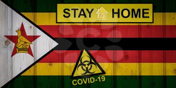 Flag of the Zimbabwe in original proportions. Quarantine and isolation - Stay at home. flag with biohazard symbol and inscription COVID-19.