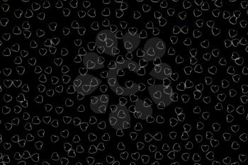 Valentine's Day abstract 3D illustration pattern with black hearts on dark background surrounded by white glow.