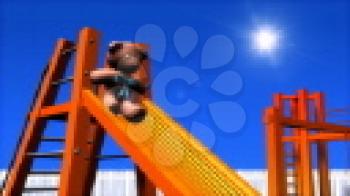 Royalty Free HD Video Clip of a Teddy Bear Going Down a Slide in a Playground
